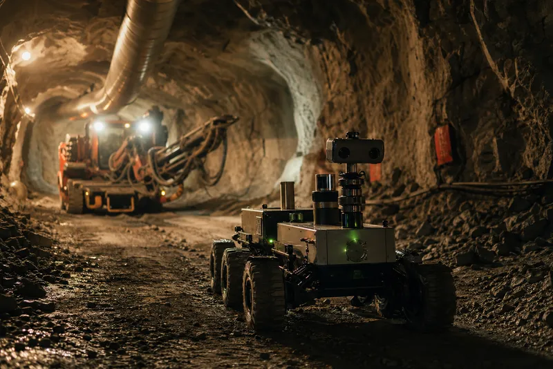Autonom robot navigerar genom gruvtunnel med industriell belysning