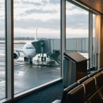 Tomt flygplatsgate i morgonljus, symbol för ledningsskifte inom flyget