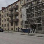Äldre hyresfastighet under renovering med byggställning, en molnig eftermiddag, relevant för avdrag renovering hyresfastig...