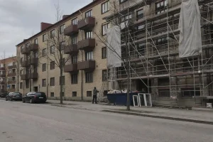 Äldre hyresfastighet under renovering med byggställning, en molnig eftermiddag, relevant för avdrag renovering hyresfastig...